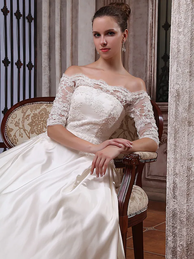 Detail of the half sleeves and satin fabric on the elegant wedding gown.