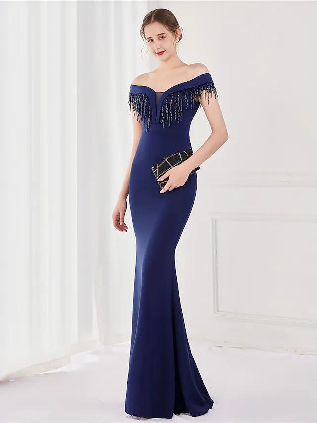 Full view of the satin mermaid trumpet dress, highlighting its elegant silhouette and tassel detail.