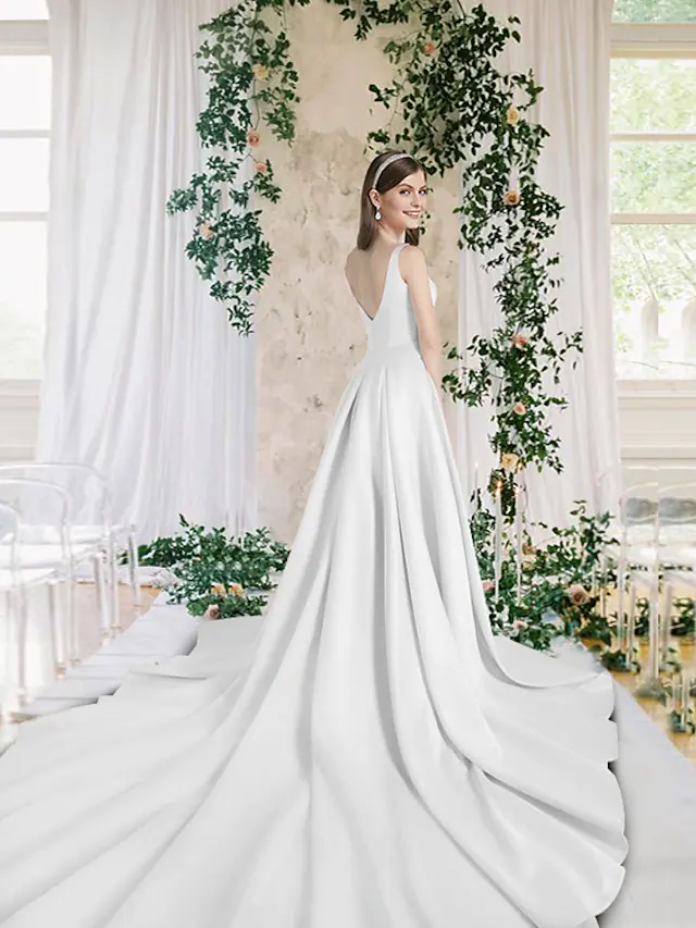 Back view of a V-neck satin wedding dress with a flowing chapel train.