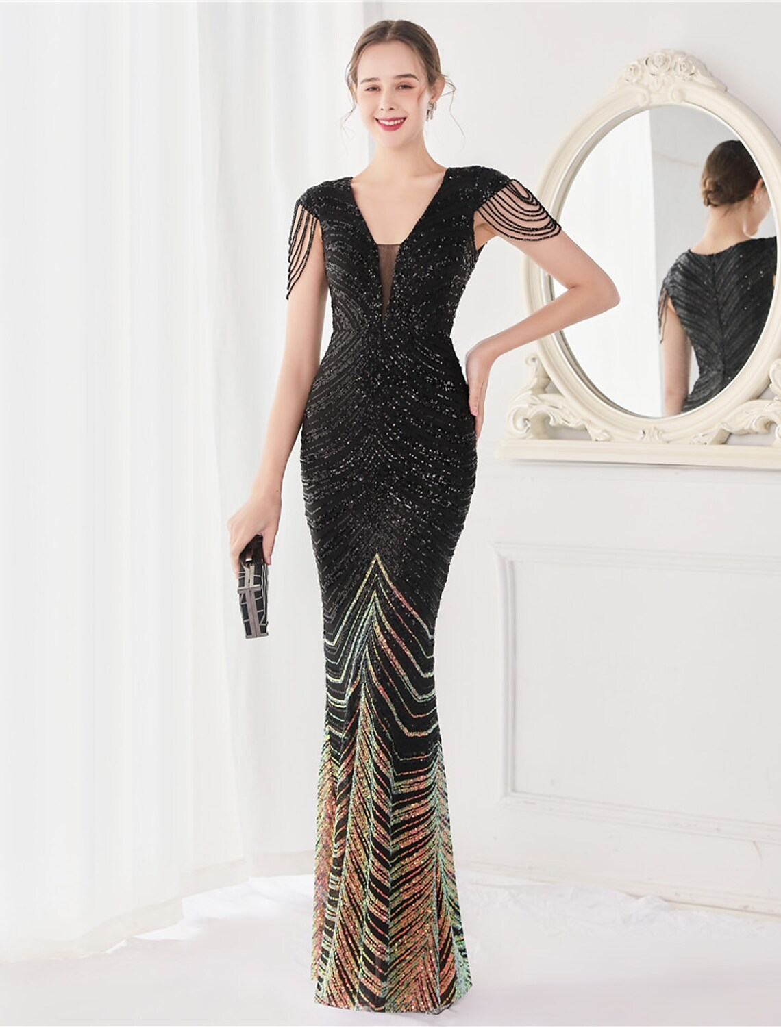 Woman wearing an elegant sequined mermaid V-neck evening gown.