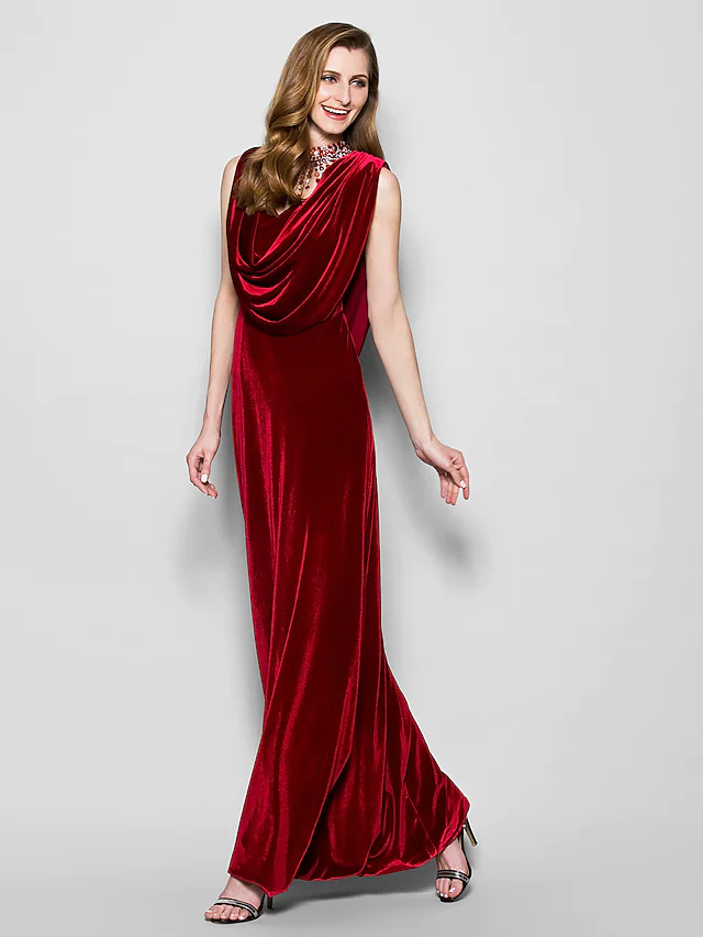Model wearing a dark velvet cowl neck floor length dress with crystal beading, front view.