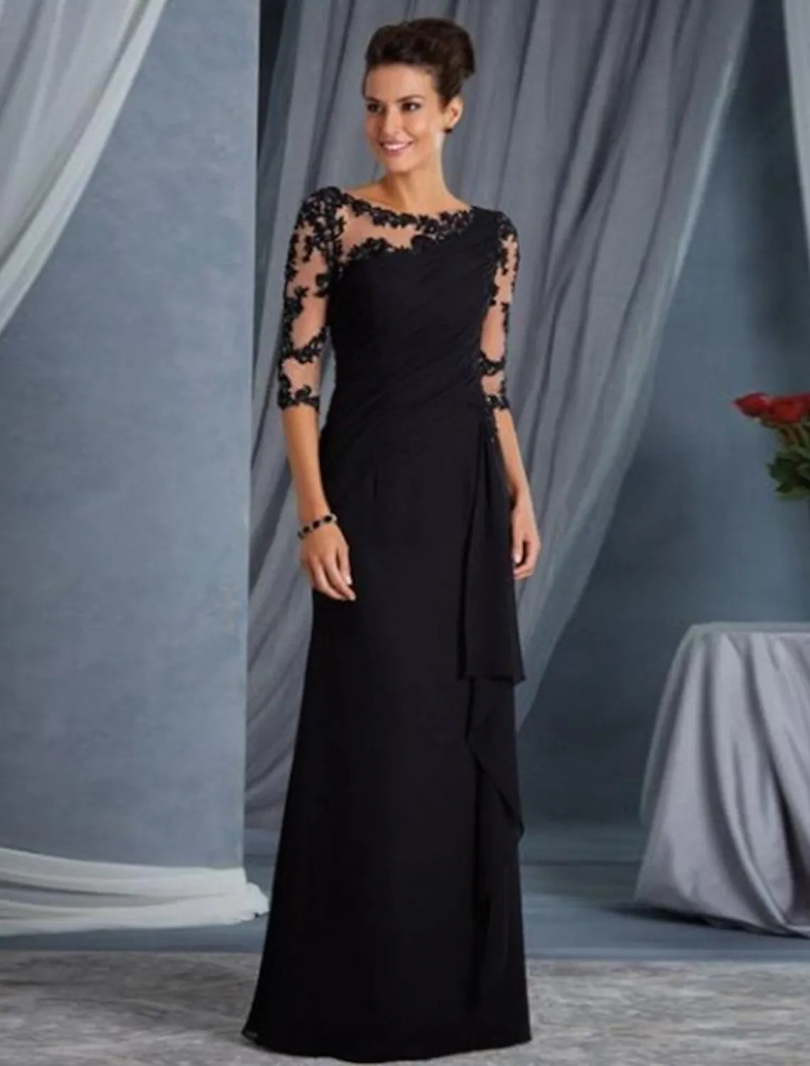 Elegant floor-length lace sheath gown with half sleeves and a jewel neck, worn by a woman.