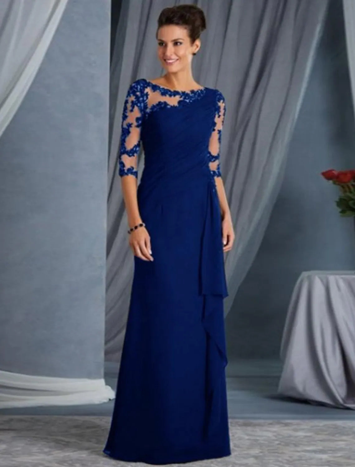Side profile of a woman wearing the half-sleeve jewel neck lace gown.