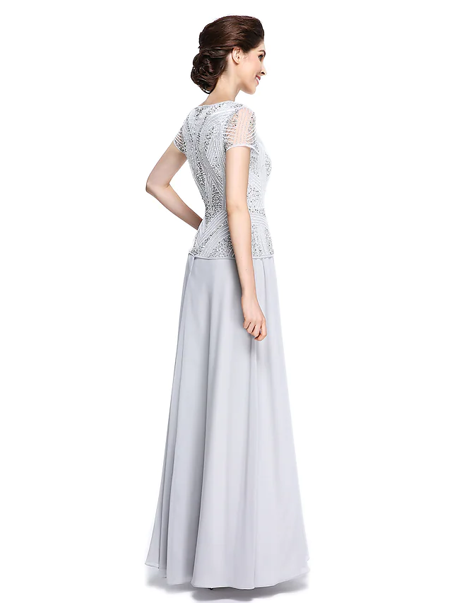 Side view of a woman in a floor-length chiffon mother of the bride gown.