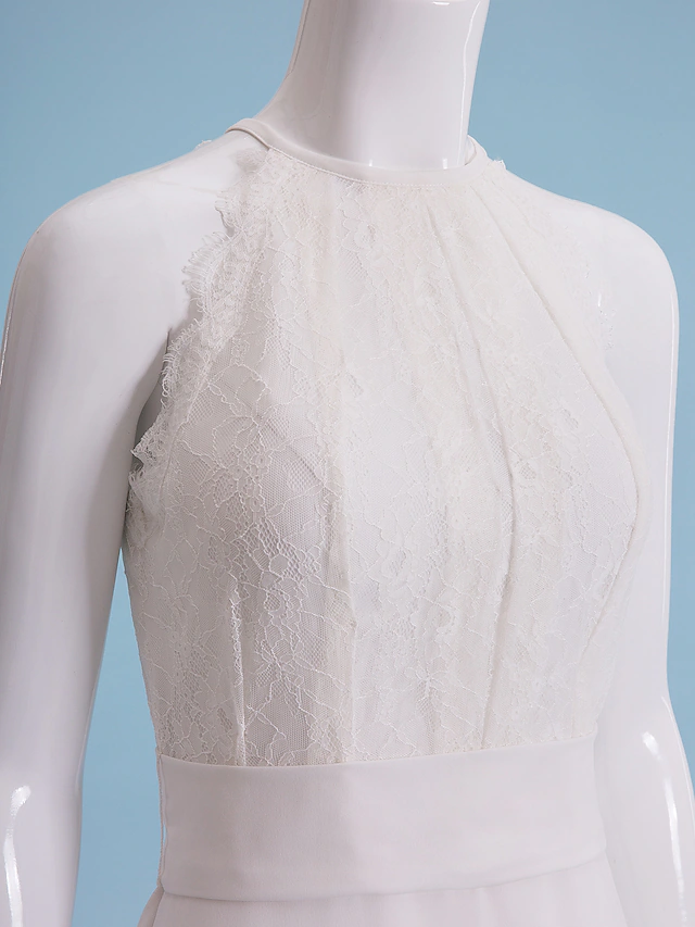 Side view of the bride in the sheath wedding dress, showcasing the silhouette and floral lace.