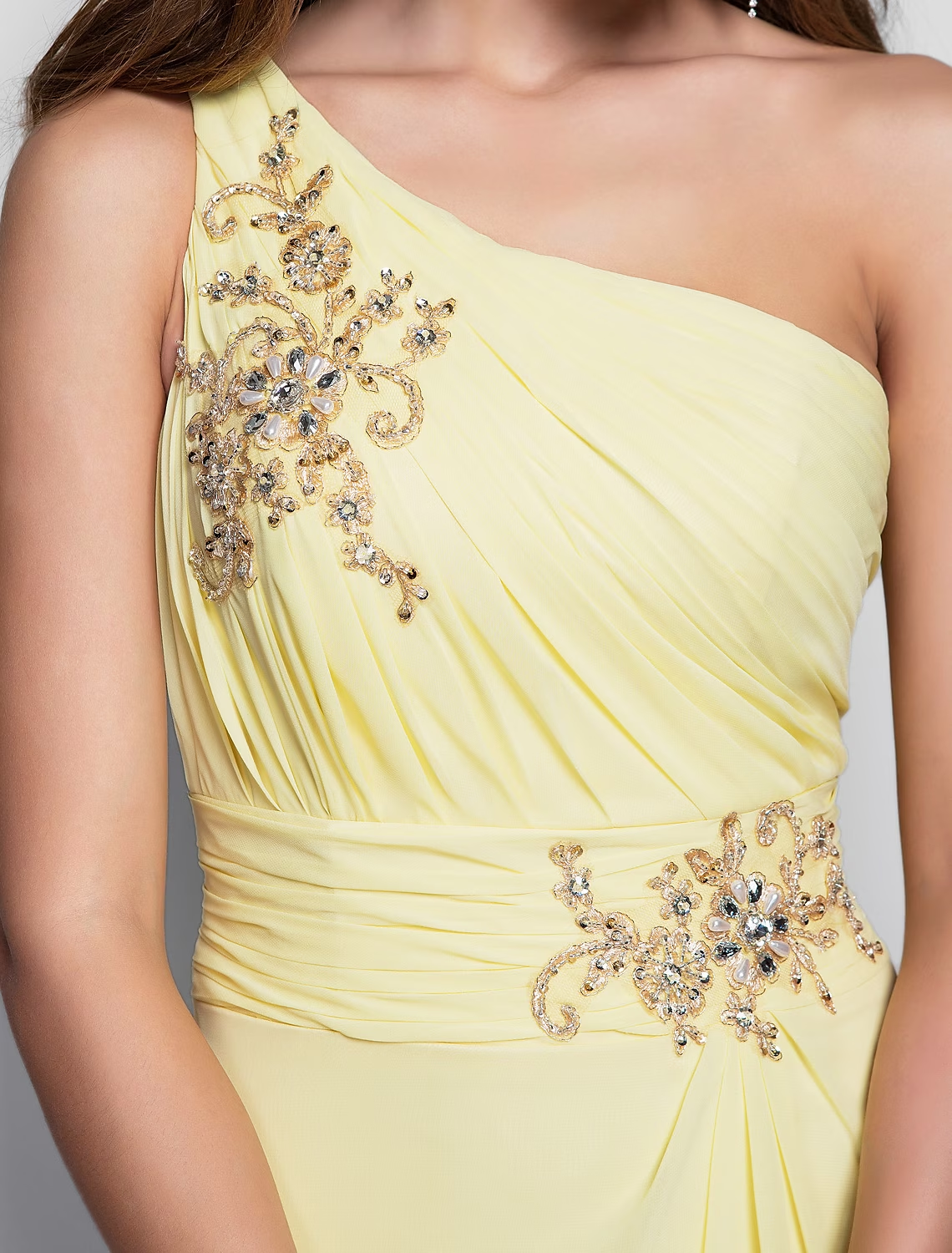 Close-up of the beaded and appliqued detail on the one-shoulder dress.