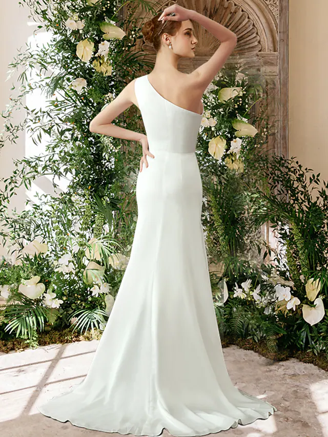 Close-up of the elegant one-shoulder chiffon wedding dress, showing fabric detail.