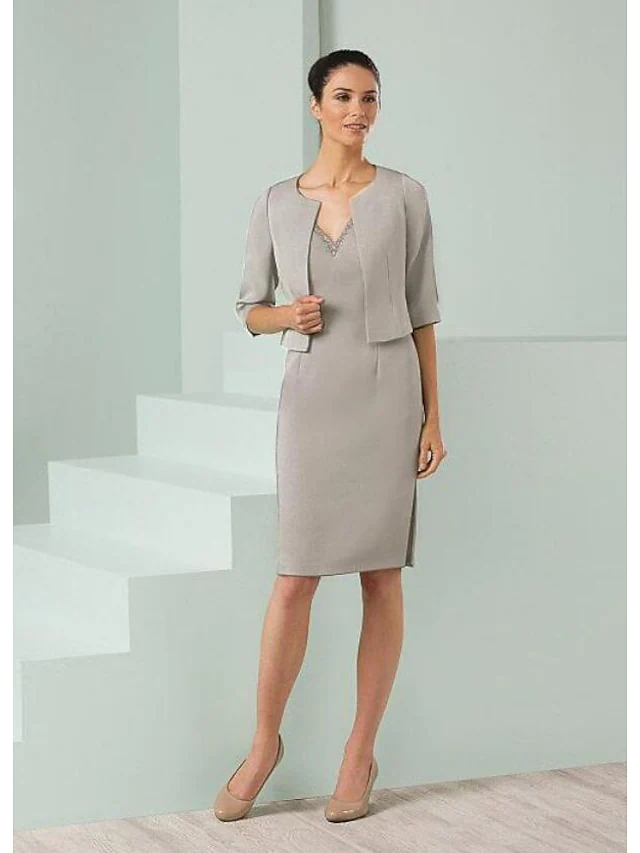 Elegant navy Mother of the Bride dress with plunging neck, half sleeves, and matching wrap.