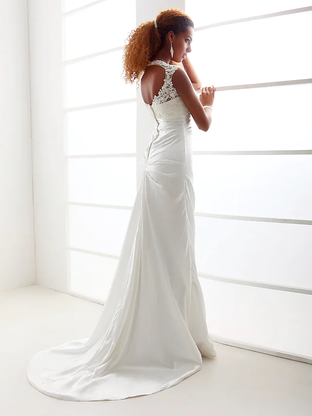 Detailed view of the charmeuse fabric and delicate appliques on the bridal gown.