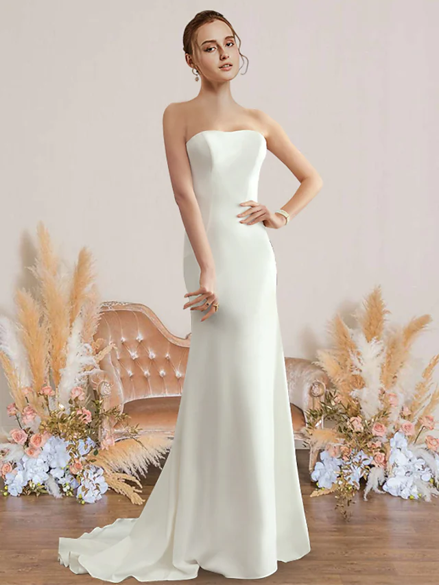Front view of an elegant strapless chiffon sheath wedding dress.