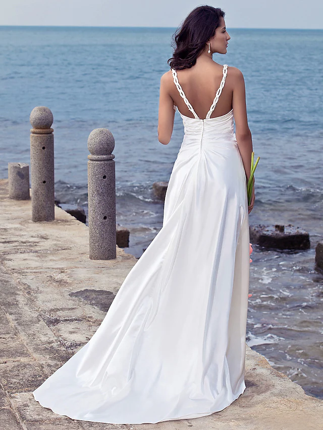 Side profile of a bride in a sheath wedding dress with a sweep train.