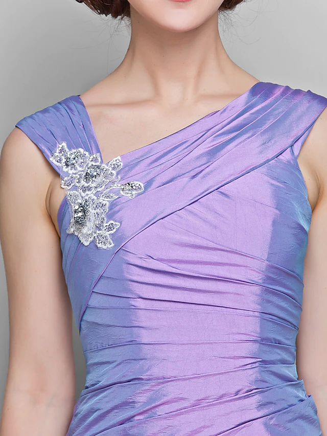 Close-up of the lace and ruched embellishments on the dress.