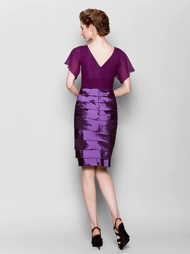 Back view of knee-length sheath dress with criss-cross detail.