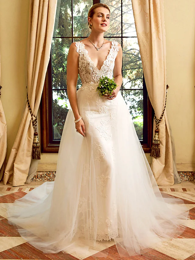 Full view of an elegant V-neck sheath wedding dress with lace appliques and a chapel train.