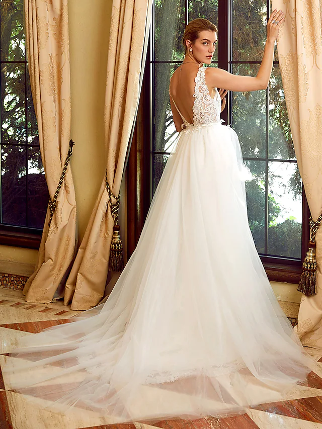 Close-up of the V-neckline and delicate lace appliques on the wedding dress.