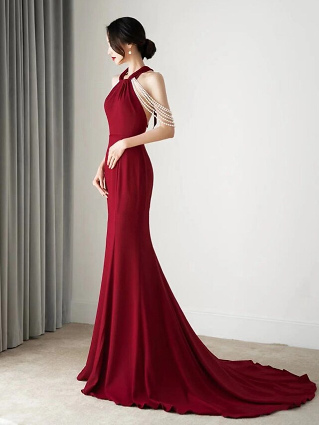 Woman wearing an elegant white halter neck fishtail wedding dress.