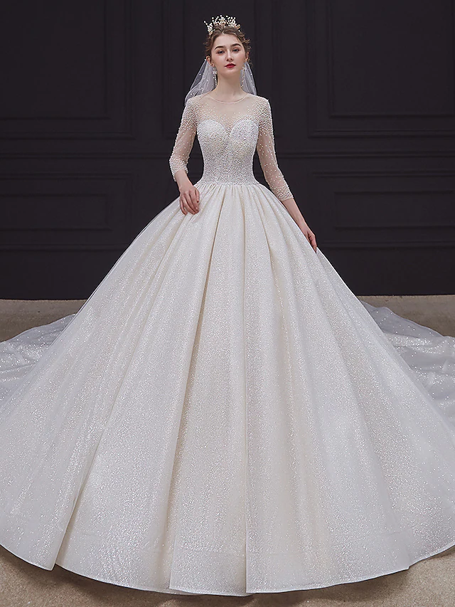 Back view of a sparkling lace and tulle wedding dress with a chapel train.