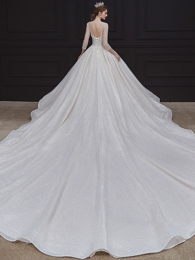 Side view of the luxurious ball gown silhouette and flowing chapel train.
