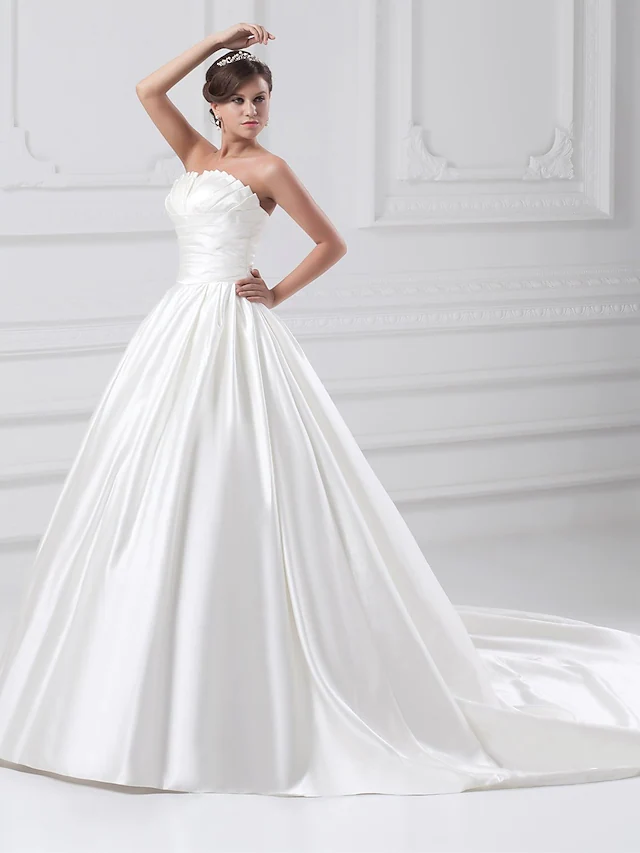Back view of a strapless satin wedding dress with a flowing court train.