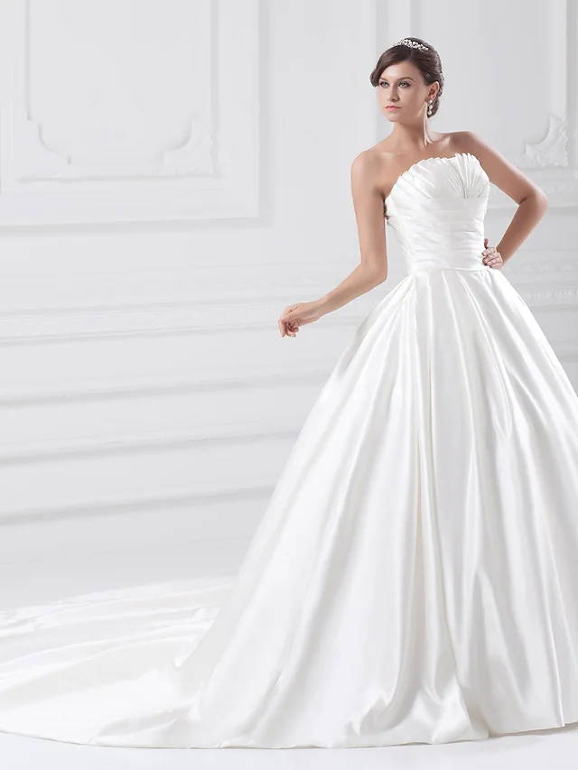 Side profile of a bride wearing a strapless ball gown wedding dress.