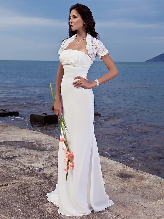 Elegant strapless mermaid wedding dress with ruched bodice.