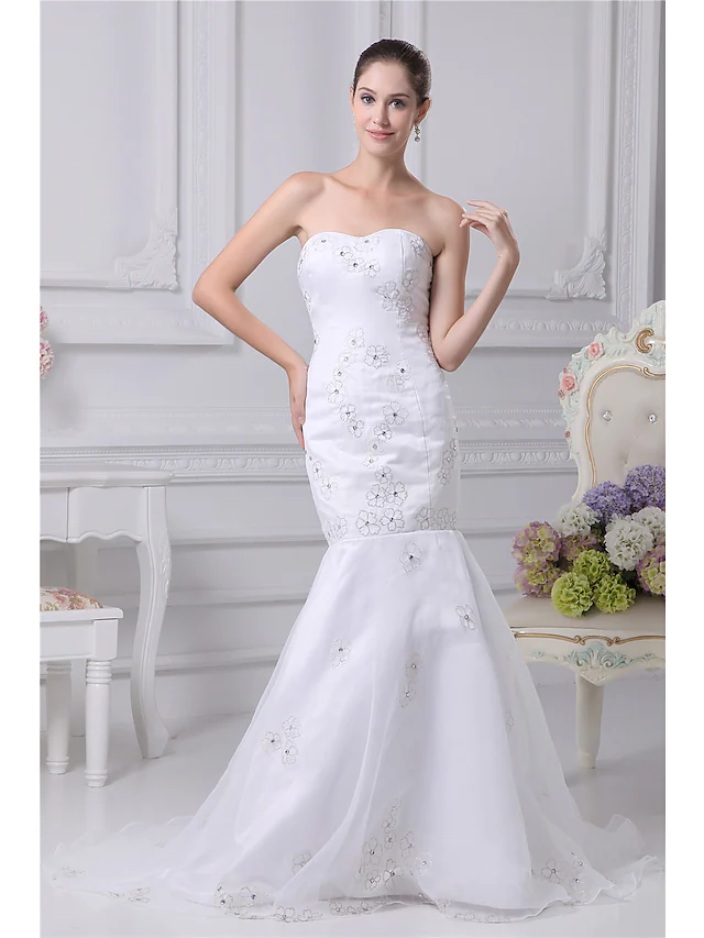 Elegant strapless mermaid wedding dress with intricate beading and embroidery, featuring a chapel train.