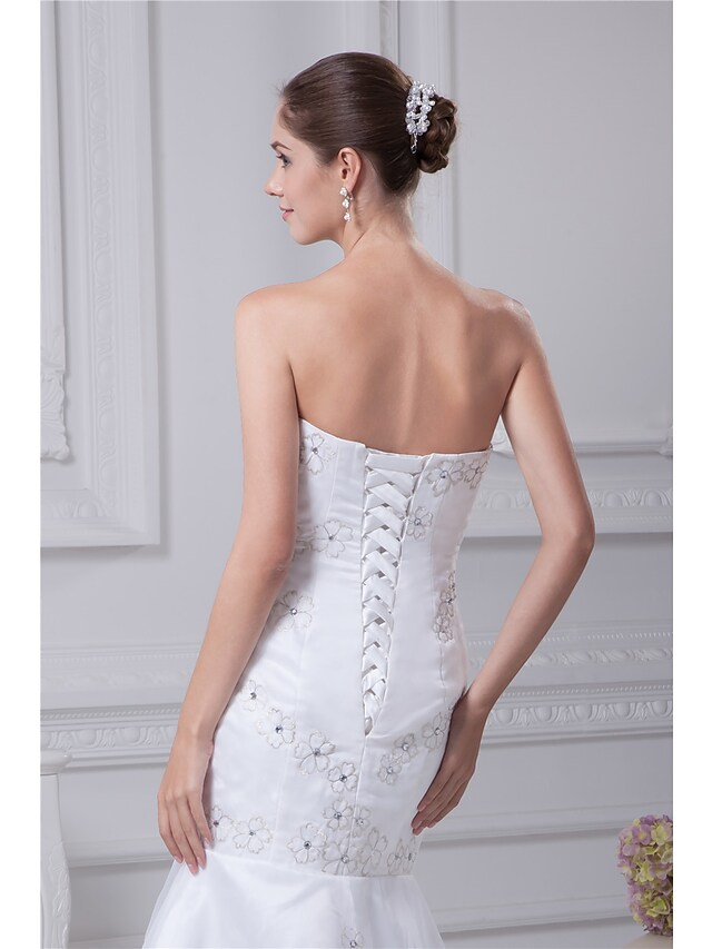 Full-length view of the bridal gown, emphasizing the mermaid silhouette and luxurious organza and satin fabric.