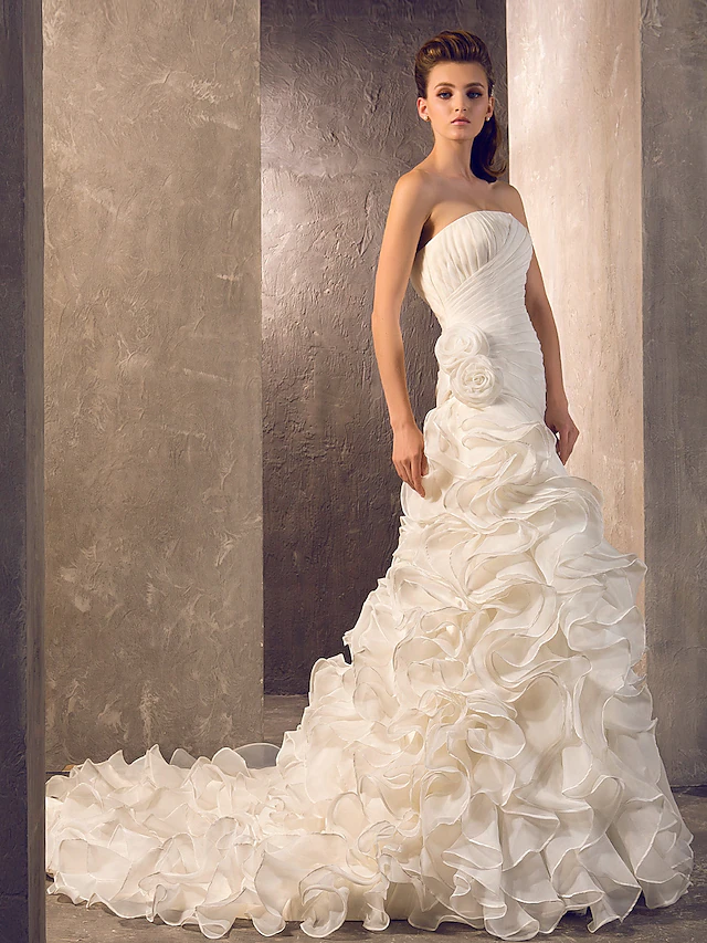 Side view of the wedding gown, highlighting the elegant side-draping and flowy skirt.