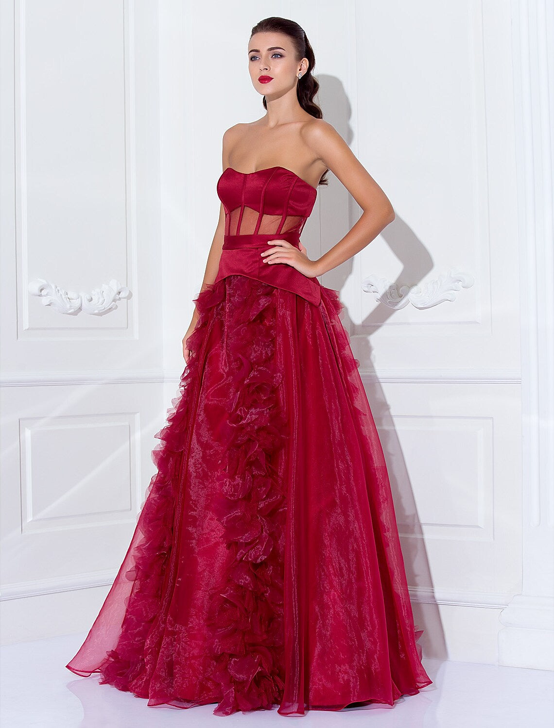 Woman wearing an elegant strapless satin ball gown with a flowing skirt.