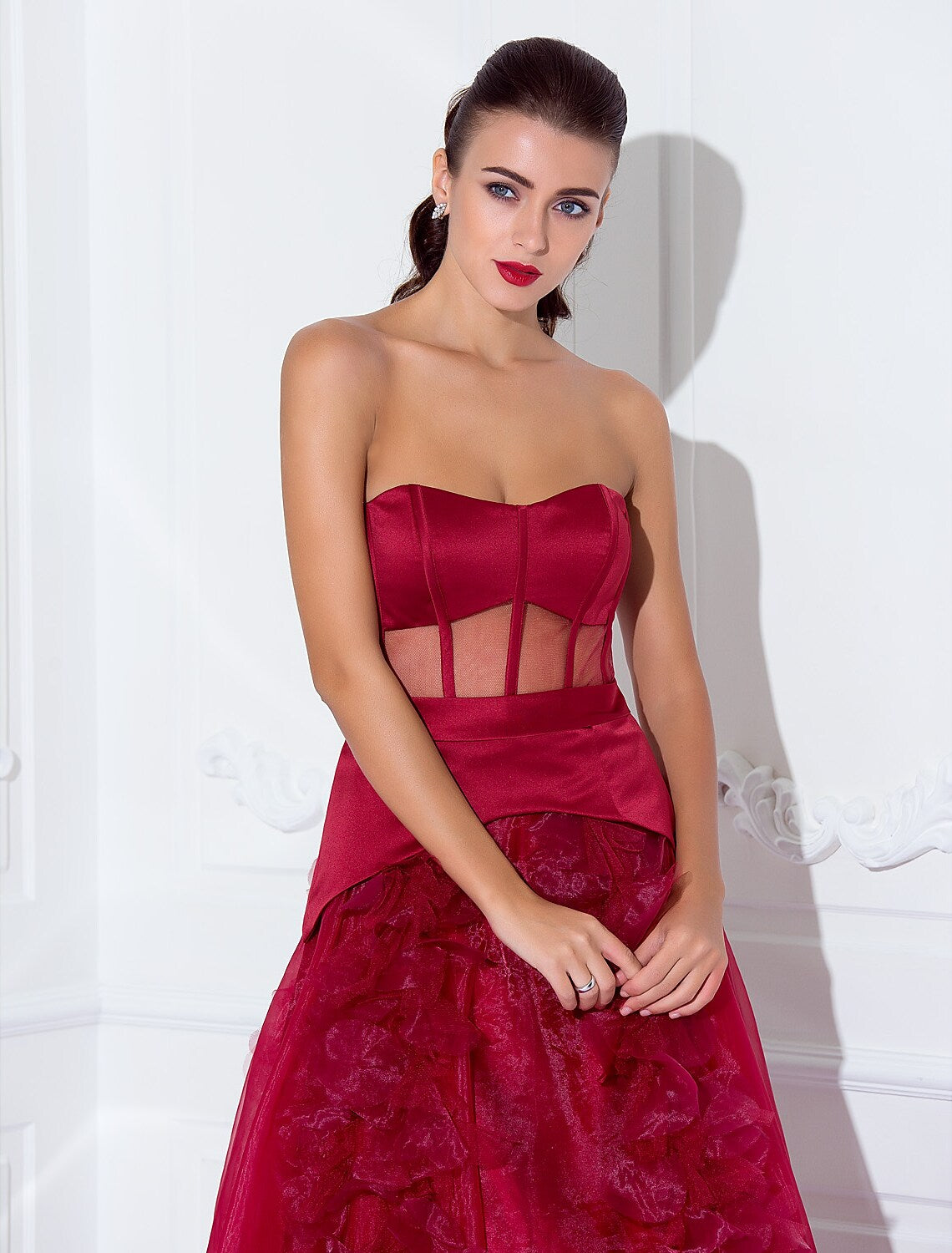 Side profile of a woman in a glamorous floor-length strapless satin dress.