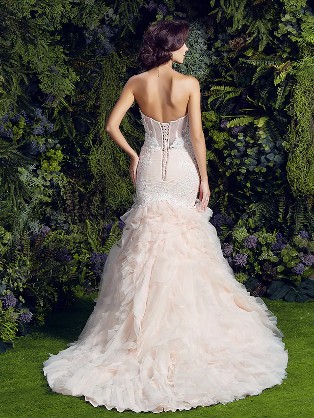 Back view of a strapless wedding dress with cascading ruffles.