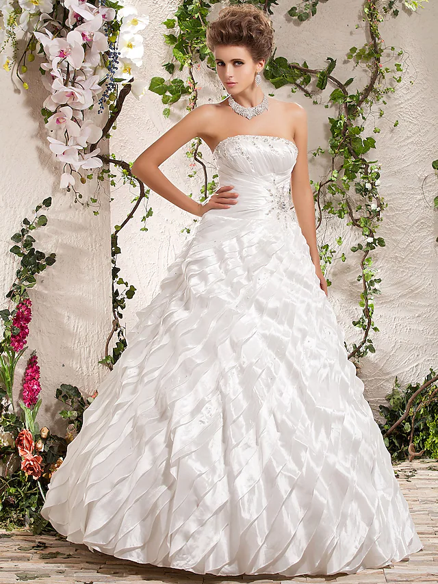Elegant strapless taffeta ball gown wedding dress with beading and ruffles.