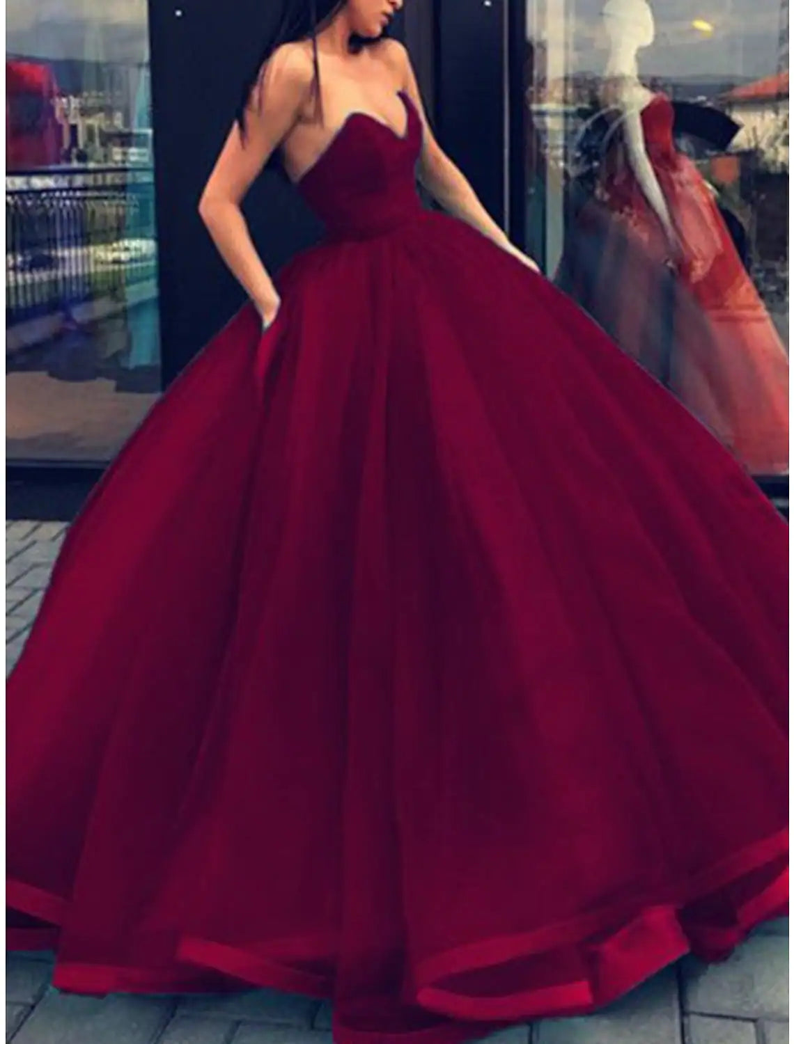 Side view of the floor-length strapless ball gown, showcasing its voluminous silhouette.