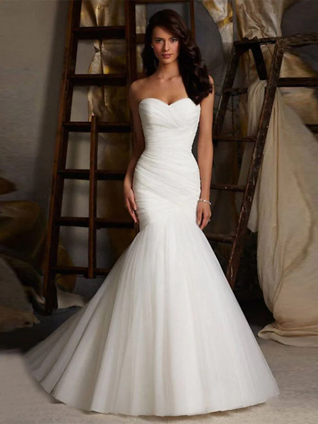 Elegant white strapless sweetheart wedding dress with ruched bodice and flowing court train.