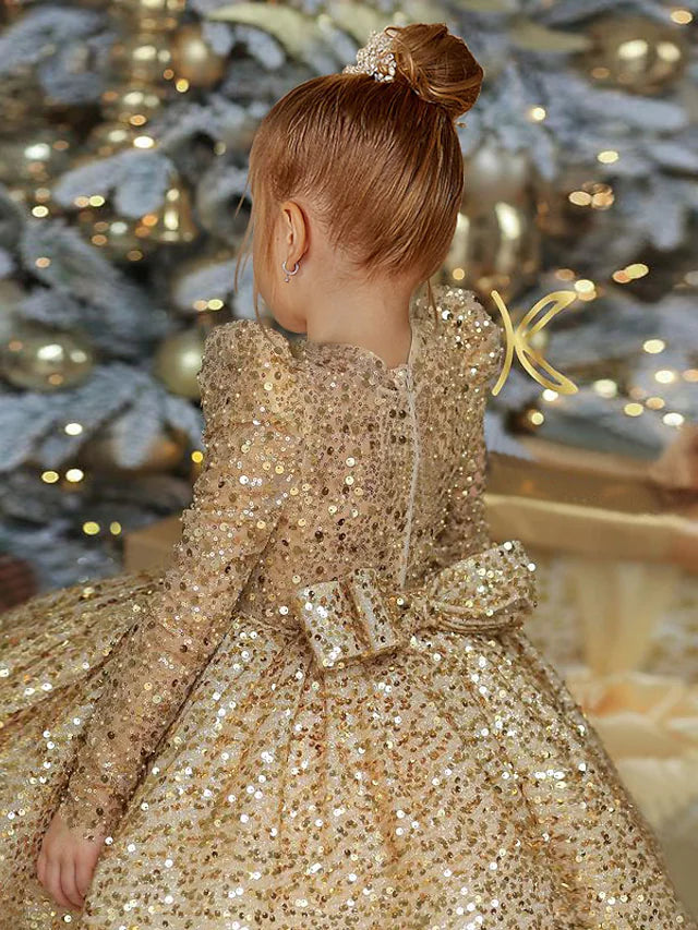 Side view of the princess tulle flower girl dress, highlighting the long sleeves and knee-length skirt.
