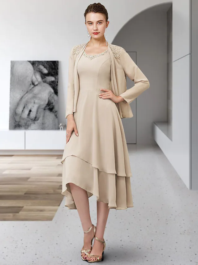 Woman wearing an elegant two-piece A-line chiffon Mother of the Bride dress with jewel neck and ruffles.