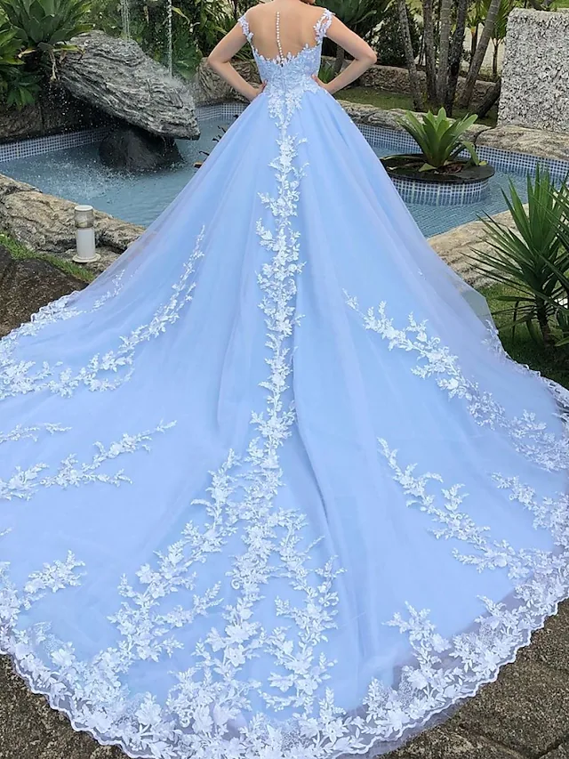 Close-up of V-neckline and delicate lace appliques on wedding dress.