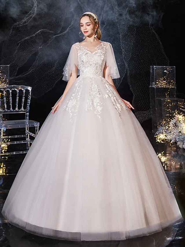 Close-up of lace appliques on V-neck wedding dress.