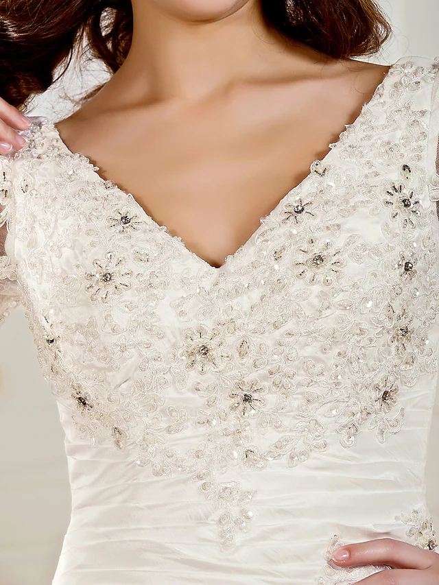 Close-up of the ruched bodice and beading appliques on the wedding dress.