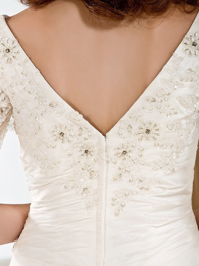 Detail of the half sleeves and V-neckline of the bridal dress.