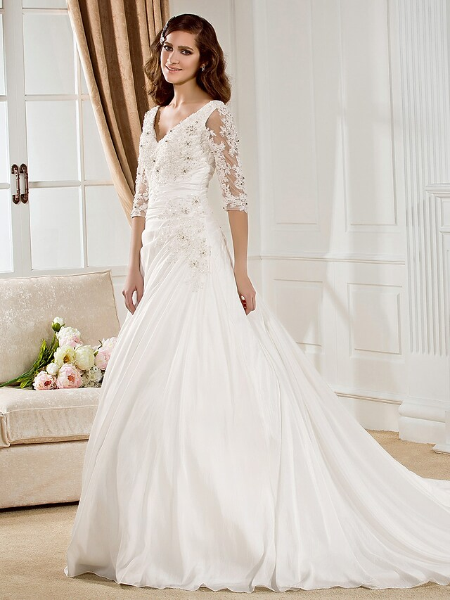 Elegant V-neck wedding dress with half sleeves and ruched details.