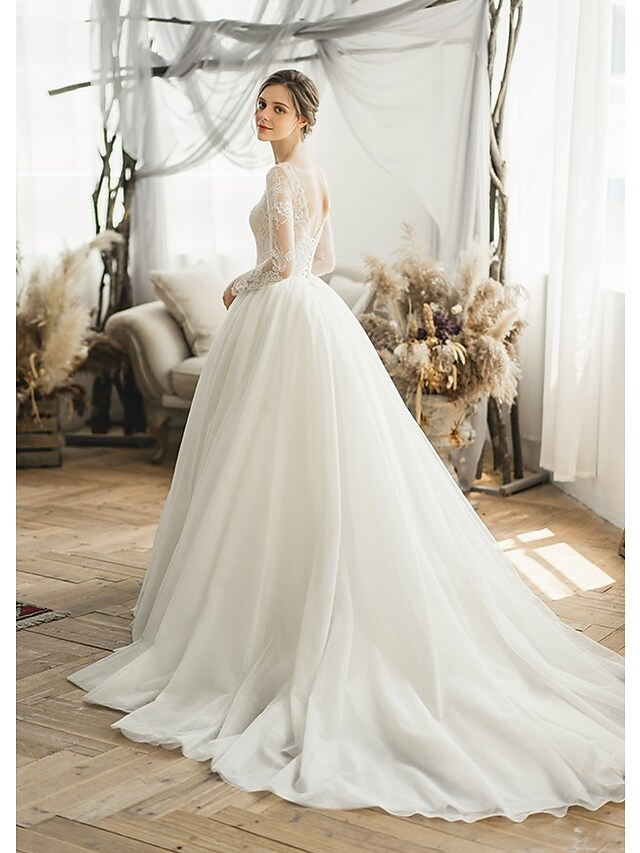 Close-up of intricate appliques on tulle wedding dress.
