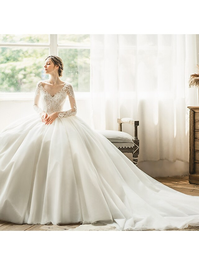 Detail of the V-neckline and long sleeves on wedding dress.