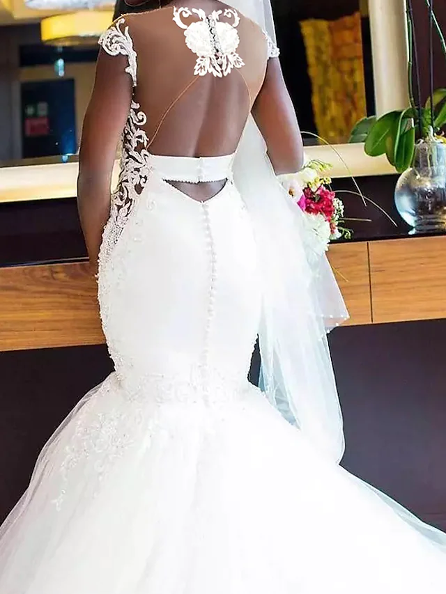 Full view of the white V-neck mermaid wedding dress, emphasizing the elegant silhouette and chapel train.