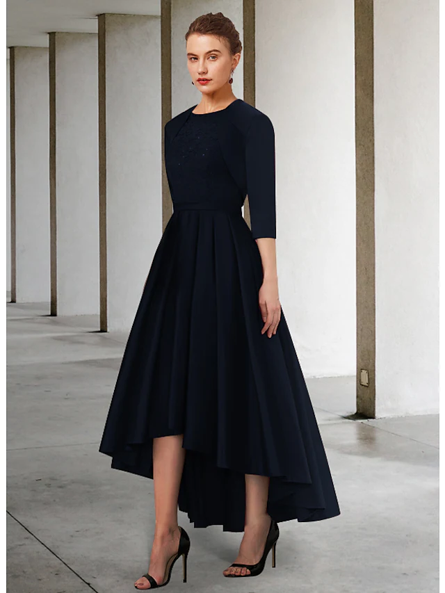 Close-up of jewel neck, 3/4 sleeve, and asymmetrical lace on the dress.