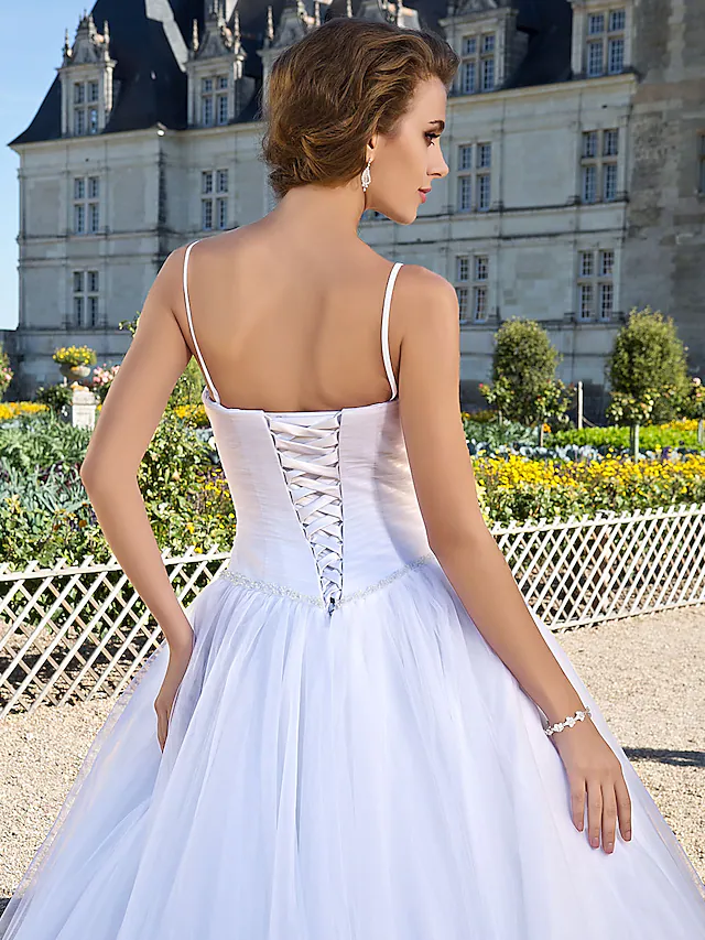Bride wearing a sleeveless white ball gown wedding dress.