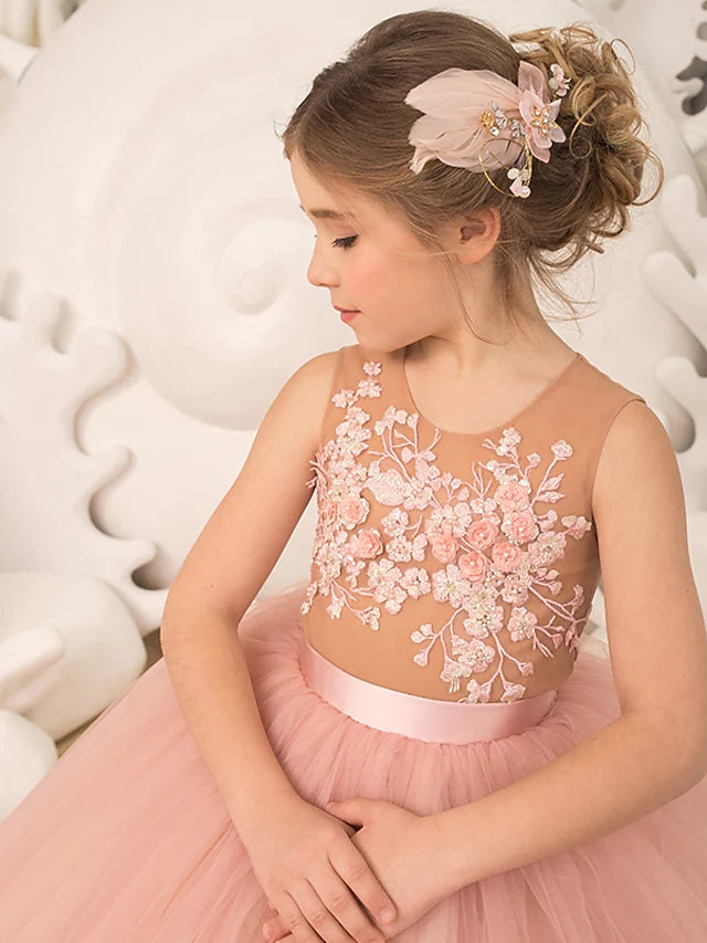 Side view of a young girl wearing an elegant white pleated tulle dress.