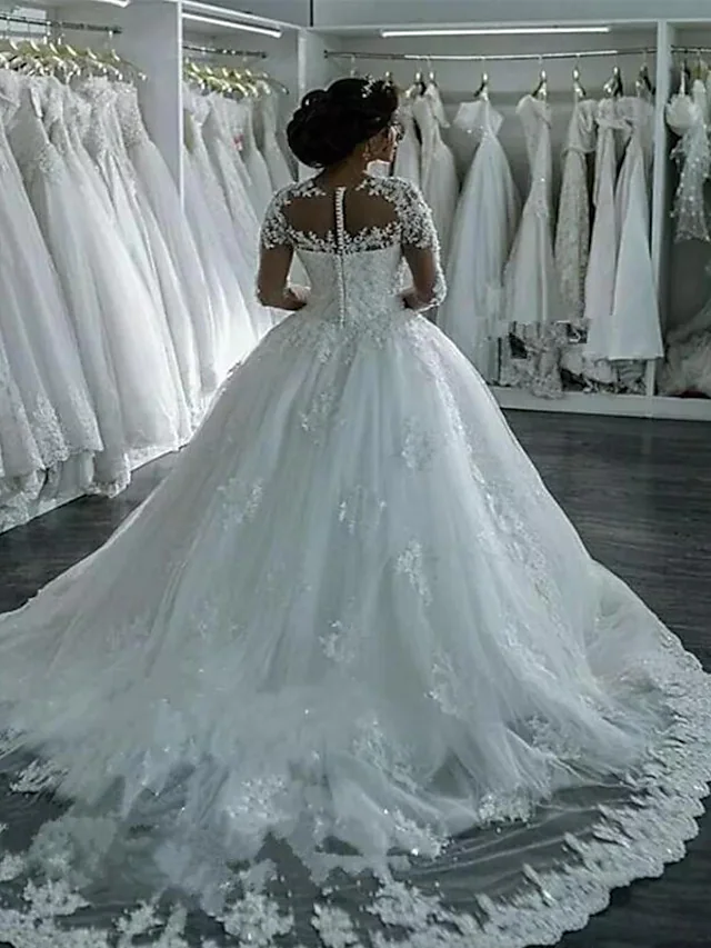 Back view of the wedding dress, highlighting the backless design and court train.