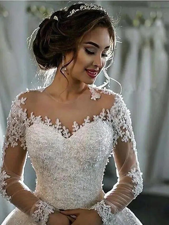 Close-up of the delicate lace and illusion long sleeves on the wedding dress.