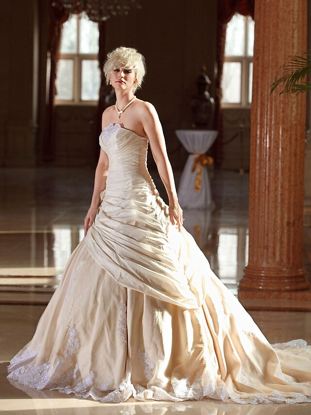 Strapless wedding dress featuring a majestic cathedral train.
